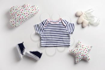 Cute baby clothes and toys on white background�