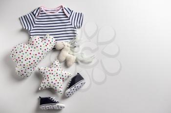 Cute baby clothes and toys on white background�
