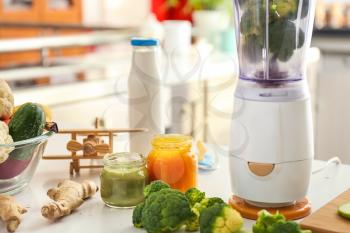 Blender and ingredients for baby food on kitchen table�