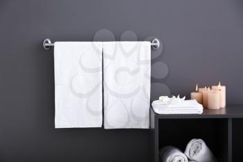 Towels with candles near grey wall�