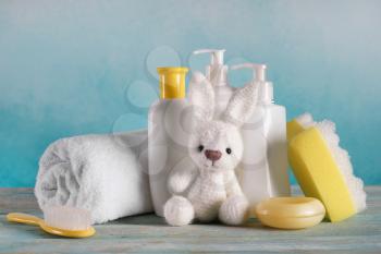 Bunny toy with cosmetics and accessories for baby on wooden table�