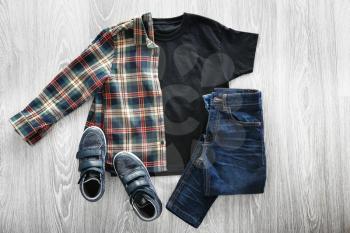 Stylish outfit with shoes on wooden background�