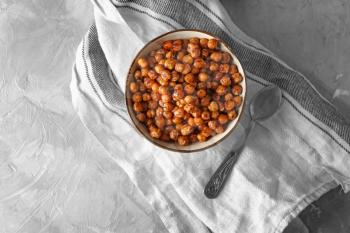 Bowl with fried chickpeas on table�