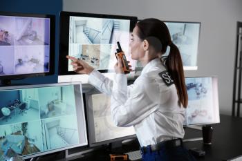 Security guard monitoring modern CCTV cameras in surveillance room�