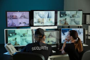 Security guards monitoring modern CCTV cameras in surveillance room�