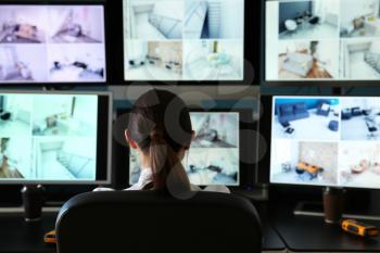 Security guard monitoring modern CCTV cameras in surveillance room�