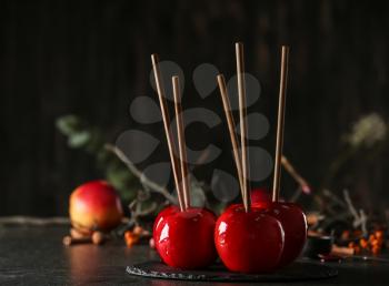 Slate plate with delicious candy apples on table�