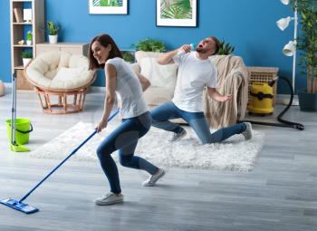Young couple having fun while cleaning their flat�