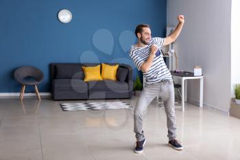 Handsome young man dancing at home�