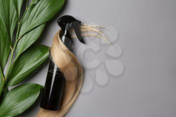 Spray bottle with cosmetic for hair on grey background, top view�