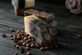 Soap bars with coffee beans on dark wooden table�