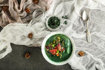 Bowl with spirulina smoothie on grey table�