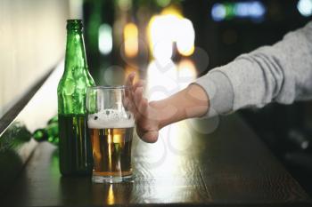 Young woman refusing to drink alcohol in bar�