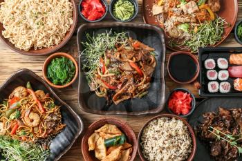 Assortment of Chinese food on wooden table�