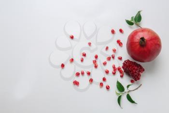 Ripe pomegranate with seeds on white background�