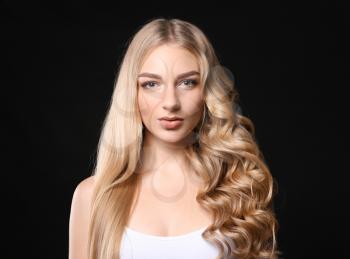 Beautiful young woman with straight and curled hair on dark background�