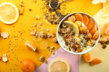 Tasty granola with yogurt and fruits in bowl on color background�