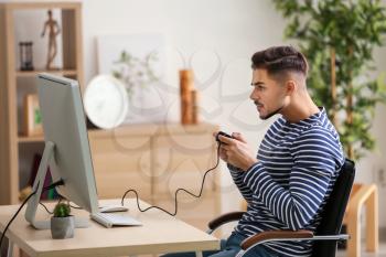 Young man playing computer game at home�