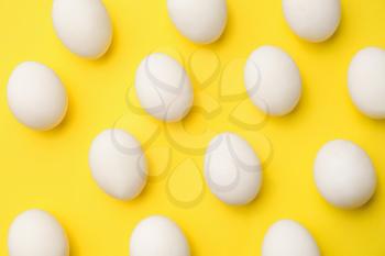Many chicken eggs on color background�
