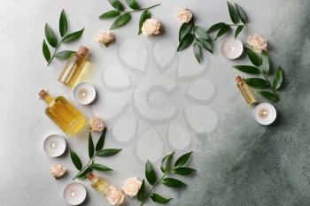 Beautiful spa composition with essential oil and candles on color background�