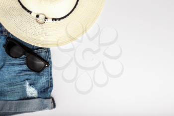Jeans shorts, hat and sunglasses on white background�