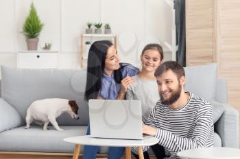 Happy family using laptop at home�