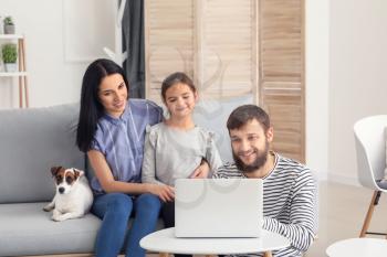 Happy family using laptop at home�