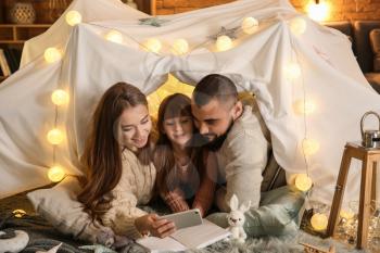 Happy family reading book at home�
