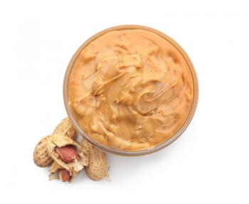 Bowl with tasty peanut butter on white background�