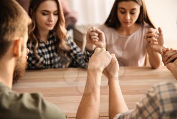 Group of people praying at table�