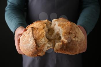 Man with loaf of fresh bread, closeup�