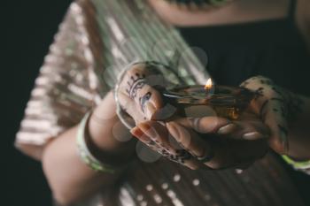 Beautiful woman with burning candle for celebration of Divaly, closeup�