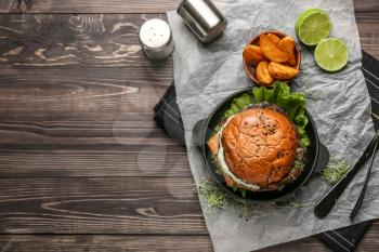 Composition with tasty burger on table�
