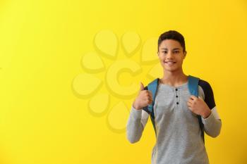 African-American schoolboy showing thumb-up on color background�