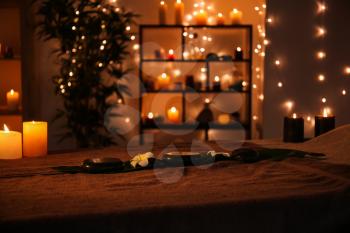 Massage stones with candles on table in spa salon�