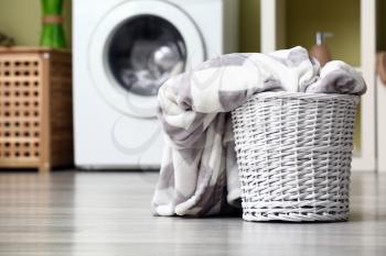 Basket with dirty laundry on floor in bathroom�