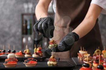Chef preparing tasty canapes for serving�