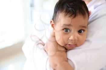 Pediatrician with cute African-American baby in clinic�