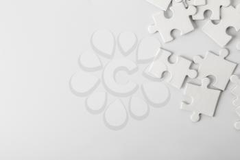 Heap of white puzzle pieces on light background�