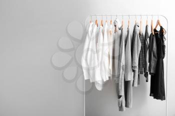Rack with stylish clothes on light background�