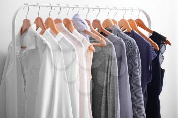 Rack with stylish clothes in room�