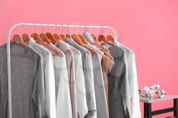 Rack with stylish clothes in room�