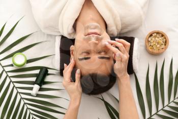 Man receiving face massage in beauty salon�