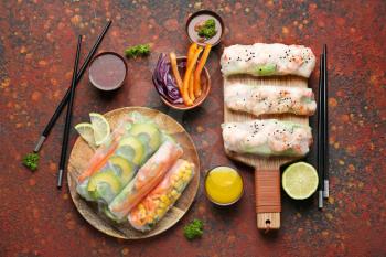 Tasty spring rolls on color table�