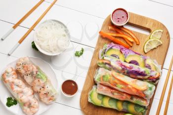 Tasty spring rolls with sauces on white table�