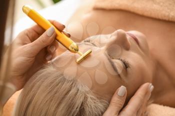 Mature woman receiving face massage in beauty salon, closeup�