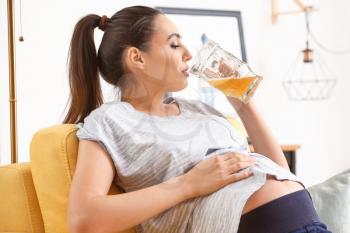 Pregnant woman drinking alcohol at home�