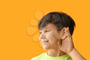 Little boy with hearing problem on color background�
