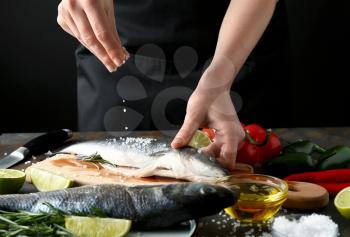 Woman preparing tasty fresh fish�