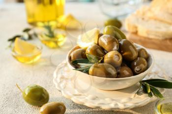 Bowl with tasty olives on grey background�